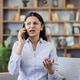 Frustrated young woman talking on phone experiencing stress Frustrated young woman talking on phone experiencing stress - PhotoDune Item for Sale