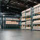 Large industrial warehouse interior with empty concrete floor and metal pallet racks filled Large industrial warehouse interior with empty concrete floor and metal pallet racks filled - PhotoDune Item for Sale