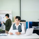 Business professional reviewing documents and reports at desk with team working in background, offic Business professional reviewing documents and reports at desk with team working in background, offic - PhotoDune Item for Sale