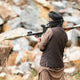 Armed militant aiming a rocket launcher during a simulated conflict scenario in rocky outdoor terrai Armed militant aiming a rocket launcher during a simulated conflict scenario in rocky outdoor terrai - PhotoDune Item for Sale