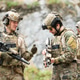 Military personnel discuss equipment and mission details during a tactical field briefing Military personnel discuss equipment and mission details during a tactical field briefing - PhotoDune Item for Sale