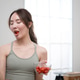 Smiling young Asian woman eating fresh cherry tomatoes in a kitchen filled with healthy ingredients Smiling young Asian woman eating fresh cherry tomatoes in a kitchen filled with healthy ingredients - PhotoDune Item for Sale