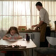 Young girl doing homework alone at the table while her father prepares food for dinner Young girl doing homework alone at the table while her father prepares food for dinner - PhotoDune Item for Sale