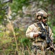 Armed soldier provides tactical cover while advancing through a training area Armed soldier provides tactical cover while advancing through a training area - PhotoDune Item for Sale
