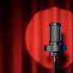 Microphone with spotlight on red stage curtain. Microphone with spotlight on red stage curtain. - PhotoDune Item for Sale