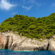 Green forest covering rocky sea cliffs and caves Green forest covering rocky sea cliffs and caves - PhotoDune Item for Sale