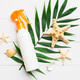 Sunscreen spray bottle. Bottle with sun protection cream and sea shells with tropical green leaf on Sunscreen spray bottle. Bottle with sun protection cream and sea shells with tropical green leaf on - PhotoDune Item for Sale