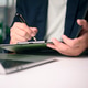 Close up businessman hand writing on clipboard paper. Professional manager signing contract agreemen Close up businessman hand writing on clipboard paper. Professional manager signing contract agreemen - PhotoDune Item for Sale