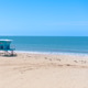 View of a blue lifeguard tower standing on the sandy beach facing the blue ocean horizon under a cle View of a blue lifeguard tower standing on the sandy beach facing the blue ocean horizon under a cle - PhotoDune Item for Sale