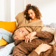 Pregnant Couple Relaxing Together at Home in a Cozy Living Room During Daytime Pregnant Couple Relaxing Together at Home in a Cozy Living Room During Daytime - PhotoDune Item for Sale