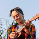 Happy teen girl playing ukulele guitar outdoor at sunset. Smiling teenage female musician in plaid s Happy teen girl playing ukulele guitar outdoor at sunset. Smiling teenage female musician in plaid s - PhotoDune Item for Sale