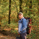 Middle-aged man with a large camouflage backpack and a bucket walking through an autumn forest. Loca Middle-aged man with a large camouflage backpack and a bucket walking through an autumn forest. Loca - PhotoDune Item for Sale