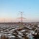 High-voltage power lines extending across snowy agricultural landscape at dusk High-voltage power lines extending across snowy agricultural landscape at dusk - PhotoDune Item for Sale
