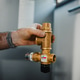 Hand holding brass plumbing valve for heat pump installation Hand holding brass plumbing valve for heat pump installation - PhotoDune Item for Sale