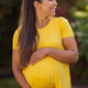 Happy pregnant woman enjoying a sunny day in a yellow dress outdoors Happy pregnant woman enjoying a sunny day in a yellow dress outdoors - PhotoDune Item for Sale