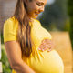 Happy pregnant woman in a bright yellow dress smiling outdoors Happy pregnant woman in a bright yellow dress smiling outdoors - PhotoDune Item for Sale