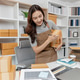 Small business owner preparing customer orders by packing boxes, checking products, recording shipme Small business owner preparing customer orders by packing boxes, checking products, recording shipme - PhotoDune Item for Sale
