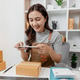 Small business owner preparing customer orders by packing boxes, checking products, recording shipme Small business owner preparing customer orders by packing boxes, checking products, recording shipme - PhotoDune Item for Sale