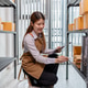 Female warehouse employee managing inventory, organizing parcel boxes, checking stock, preparing cus Female warehouse employee managing inventory, organizing parcel boxes, checking stock, preparing cus - PhotoDune Item for Sale