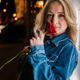 Woman holds a rose while standing near a doorway at night in a town setting Woman holds a rose while standing near a doorway at night in a town setting - PhotoDune Item for Sale