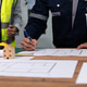 avEngineers reviewing construction blueprints with building model avEngineers reviewing construction blueprints with building model - PhotoDune Item for Sale