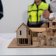 Architectural scale model of modern houses on desk during meeting with engineers and safety staff in Architectural scale model of modern houses on desk during meeting with engineers and safety staff in - PhotoDune Item for Sale
