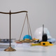 Brass balance scale on a desk with blurred safety helmet and tools in background, representing justi Brass balance scale on a desk with blurred safety helmet and tools in background, representing justi - PhotoDune Item for Sale