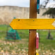 Yellow wooden arrow sign on post outdoors. Symbol of direction, guidance and creative navigation. Co Yellow wooden arrow sign on post outdoors. Symbol of direction, guidance and creative navigation. Co - PhotoDune Item for Sale