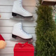 White ice skates displayed on festive wall with red gift box and greenery. Winter holiday decor, sea White ice skates displayed on festive wall with red gift box and greenery. Winter holiday decor, sea - PhotoDune Item for Sale