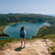 Young adult woman standing on a mountain peak admiring lago do fogo in the azores Young adult woman standing on a mountain peak admiring lago do fogo in the azores - PhotoDune Item for Sale
