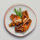 Fried artichoke halves with fresh green rosemary sprig served on bright white plate. Minimalist high Fried artichoke halves with fresh green rosemary sprig served on bright white plate. Minimalist high - PhotoDune Item for Sale