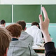 A view from behind a student answering a question during a university lecture. A view from behind a student answering a question during a university lecture. - PhotoDune Item for Sale
