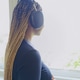 A young African-American woman with headphones on is standing by the window, listening to music and A young African-American woman with headphones on is standing by the window, listening to music and - PhotoDune Item for Sale