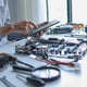 IT technician using tablet while repairing laptop motherboard and computer hardware components. IT technician using tablet while repairing laptop motherboard and computer hardware components. - PhotoDune Item for Sale