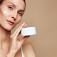 Close up of a woman applying face cream for beauty hydration, beige background, calm smile, skincare Close up of a woman applying face cream for beauty hydration, beige background, calm smile, skincare - PhotoDune Item for Sale