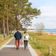 Two people walking by the sea. Coastal outdoor recreation scene. Two people walking by the sea. Coastal outdoor recreation scene. - PhotoDune Item for Sale