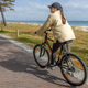 Woman cycling beside the sea. Active outdoor recreation on coastal path. Woman cycling beside the sea. Active outdoor recreation on coastal path. - PhotoDune Item for Sale