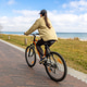 Woman cycling on seaside promenade. Active outdoor leisure near the coast. Woman cycling on seaside promenade. Active outdoor leisure near the coast. - PhotoDune Item for Sale
