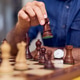 Man Strategically Playing Chess on a Well-Lit Wooden Board Man Strategically Playing Chess on a Well-Lit Wooden Board - PhotoDune Item for Sale