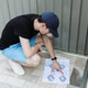 A young man studies a paper instruction manual for assembling a metal shed. A young man studies a paper instruction manual for assembling a metal shed. - PhotoDune Item for Sale
