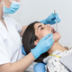 Young woman receiving dental check-up in a modern dental office Young woman receiving dental check-up in a modern dental office - PhotoDune Item for Sale