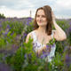 Young woman standing in a field of purple flowers at summer time. Girl enjoying nature and fresh air Young woman standing in a field of purple flowers at summer time. Girl enjoying nature and fresh air - PhotoDune Item for Sale