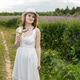 Woman holding wildflower while standing in meadow during sunny day. Girl wearing white dress and hat Woman holding wildflower while standing in meadow during sunny day. Girl wearing white dress and hat - PhotoDune Item for Sale