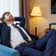 Corporate traveler reclining in armchair enjoying rest in modern hotel suite after journey Corporate traveler reclining in armchair enjoying rest in modern hotel suite after journey - PhotoDune Item for Sale