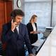 Male receptionist using landline phone at luxury hotel front desk Male receptionist using landline phone at luxury hotel front desk - PhotoDune Item for Sale