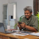 Smiling man using smartphone working from home Smiling man using smartphone working from home - PhotoDune Item for Sale