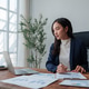 Young asian woman working from home office reviewing financial data Young asian woman working from home office reviewing financial data - PhotoDune Item for Sale