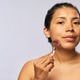 Portrait of Hispanic Adult Woman Using Facial Roller for Skin Care Portrait of Hispanic Adult Woman Using Facial Roller for Skin Care - PhotoDune Item for Sale