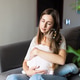 Young mother comforting her daughter while sitting on a sofa at home Young mother comforting her daughter while sitting on a sofa at home - PhotoDune Item for Sale