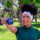 Young woman exercising with dumbbell in park Young woman exercising with dumbbell in park - PhotoDune Item for Sale